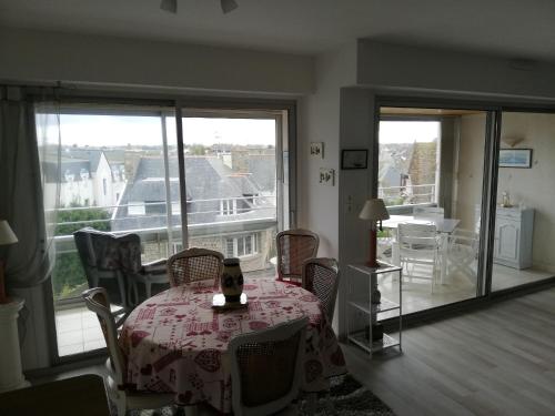een eetkamer met een tafel en stoelen en een balkon bij Le Courtois in Saint-Malo