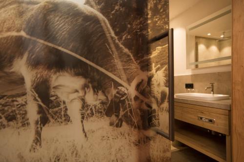 une salle de bains avec une photo d'un cheval sur le mur dans l'établissement Hotel Stubai, à Schönberg im Stubaital