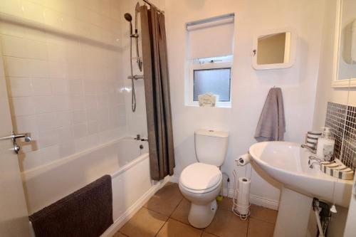 a white bathroom with a toilet and a sink at Clifton Park in Belfast