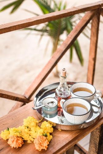 a tray of food with two cups of coffee on a table at Ravi Yoga Retreat in Polem