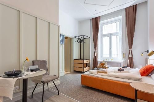 a bedroom with a bed and a table and a desk at Gellért Budapest Suites in Budapest