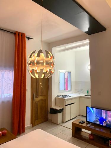 a living room with a television and a chandelier at Nandy's home in Odza II