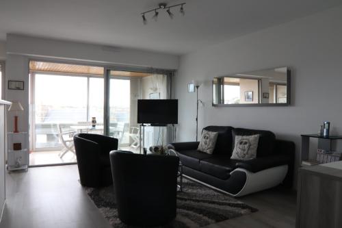 un salon avec un canapé et un miroir dans l'établissement Le Courtois, à Saint-Malo