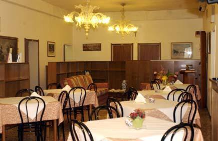 a dining room with tables and chairs and a chandelier at Hotel Airone in Venice