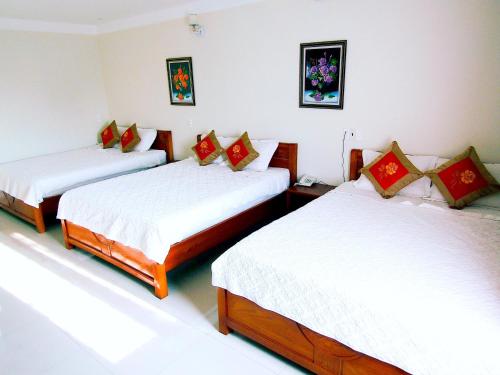 a room with two beds with white and red pillows at Hoang Dat Hotel in Dong Hoi