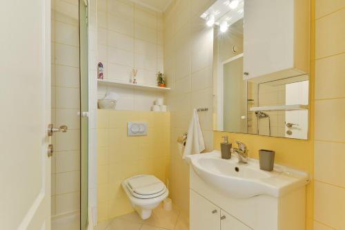 un bagno con lavandino, WC e specchio di Apartments Đaković II a Pakoštane