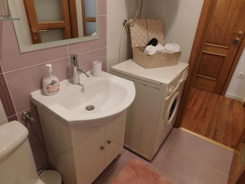 a bathroom with a sink and a toilet and a mirror at Apartman Ana in Županja