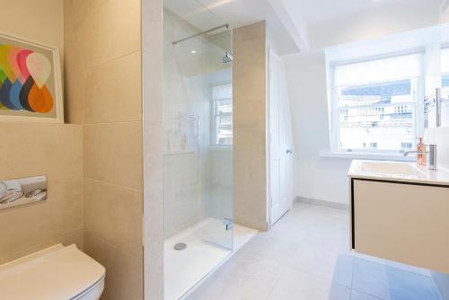 a bathroom with a shower and a toilet and a sink at Stunning & Central Milsom Street Apartment in Bath