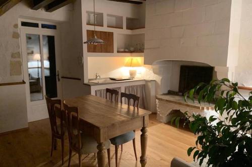 Il comprend une cuisine et une salle à manger avec une table et une cheminée. dans l'établissement Romantic anciens cottage in a beautiful park, à La Fontaine-Saint-Martin