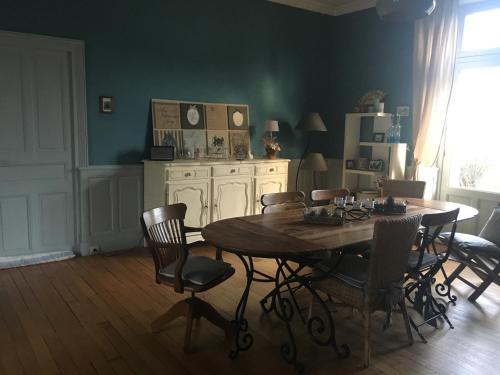 uma sala de jantar com uma mesa de madeira e cadeiras em Augustodun'Home em Autun