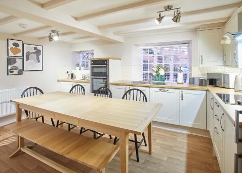 a kitchen with a wooden table and chairs at Host & Stay - Middle Farmhouse in Whitby