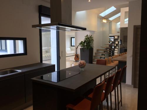 une cuisine avec un îlot doté d'un comptoir et de chaises dans l'établissement VILLA OCEANE, à Cannes