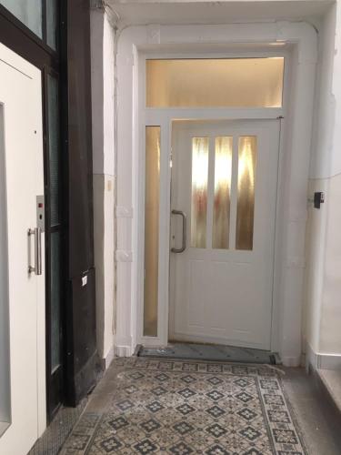 a white door in a room with a tile floor at Gellért Budapest Suites in Budapest