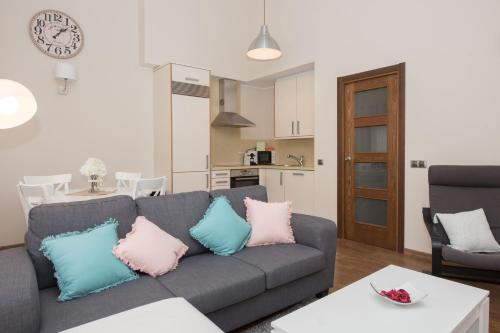 a living room with a gray couch with pink and blue pillows at Apartamento cerca de Pistas in Bordes d´Envalira