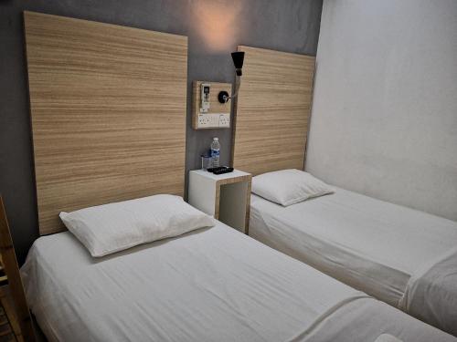 two beds in a small room with at Dragon Door Hotel in Sitiawan