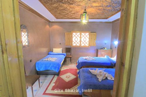 een kamer met twee bedden met blauwe lakens bij Gite Ghazal - Atlas Mountains Hotel in Imlil
