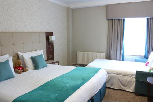 a hotel room with two beds and a teddy bear at Best Western Red Lion Hotel in Salisbury