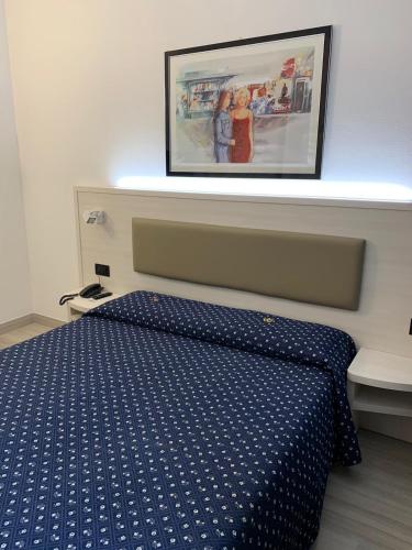 a bedroom with a bed with a blue comforter at Hotel Giotto in Padova