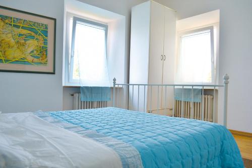 een slaapkamer met een bed en 2 ramen bij La Casa Dell'Artista in Fermo