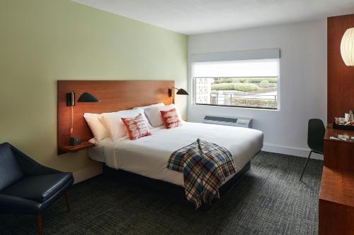 um quarto de hotel com uma cama grande e uma janela em The Longleaf Hotel em Raleigh