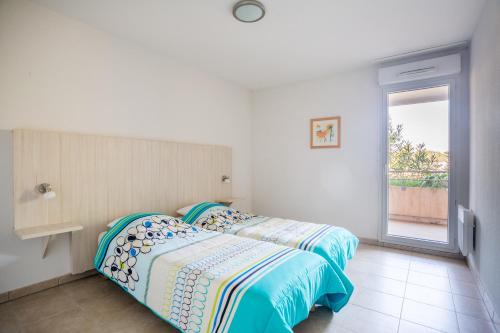 a bedroom with a bed and a window in it at Les Parasols d'Argens in Roquebrune-sur-Argens