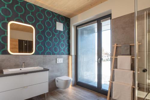 ein Badezimmer mit einem WC, einem Waschbecken und einem Spiegel in der Unterkunft ARTMUR Apartment in Sankt Georgen ob Murau