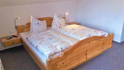 1 cama con marco de madera en una habitación en Biobauernhof Graggaber-Großeck, en Mauterndorf