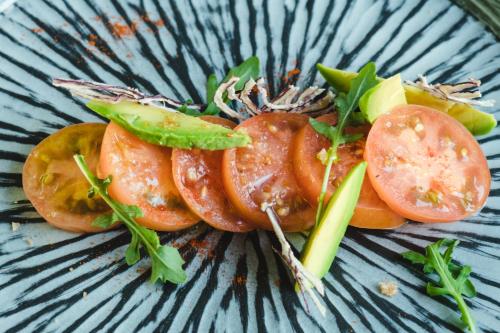 a plate of food with tomatoes and other vegetables at Kamezí Boutique Hotel Villas in Playa Blanca