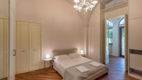 - une chambre blanche avec un lit et un lustre dans l'établissement Palazzo Acquaviva - Il Giardino Sospeso, à Lecce