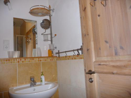 een badkamer met een wastafel en een spiegel bij Haus Bergwiese - für Naturfreunde, Familien, Wanderer in Gehlberg