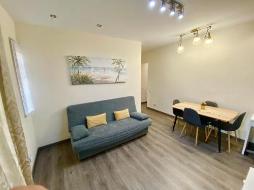 uma sala de estar com um sofá azul e uma mesa em LOVELY APARTMENT- TERRACE+BALCONY+WI-FI em Badalona