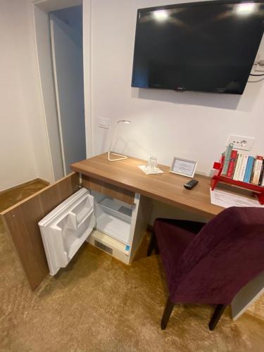 a desk with a television on a wall with a chair at Halvat Guesthouse in Sarajevo