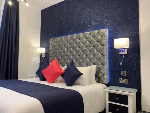 a hotel room with a bed with red and blue pillows at The 25 Boutique B&B - Adults Only in Torquay