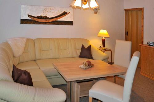 sala de estar con sofá y mesa en Ferienwohnung "An den Kurwiesen", en Masserberg