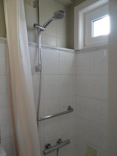 a shower with a shower curtain in a bathroom at Studio Ross, zonnig en gezellig en vlakbij de zee in Westende-Bad
