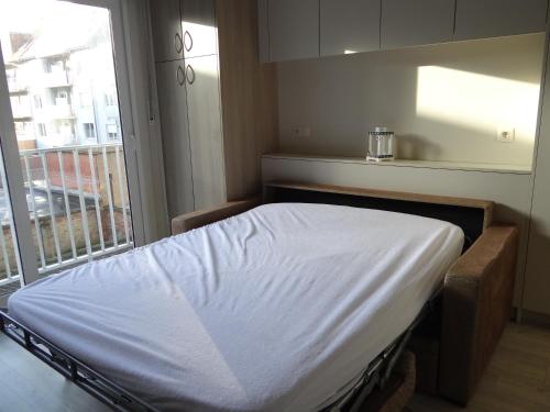 a hospital bed in a room with a window at Studio Ross, zonnig en gezellig en vlakbij de zee in Middelkerke