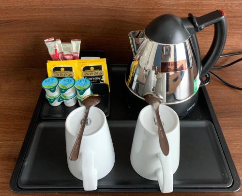 a tray with a cup of coffee and a tea kettle on it at Piries Hotel in Edinburgh