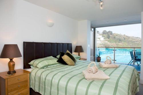 a bedroom with a large bed with towels on it at Millendreath at Westcliff - Self Catering flat with amazing sea views in Looe