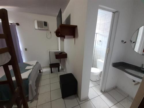 a bathroom with a sink and a toilet and a mirror at Pousada Oceano Azul in Guarapari