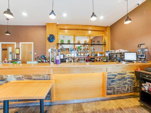 a bar in a restaurant with a counter at Standing Stones Lodge in Belfast