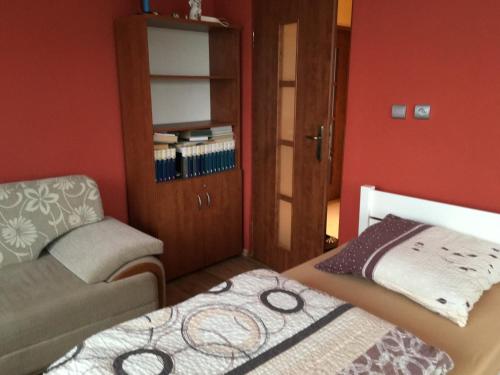 a small bedroom with a bed and a chair at Agroturystyka u Witka in Brynica Mokra