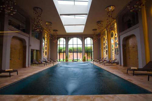 a swimming pool in a room with chairs and windows at Kenzi Club Agdal Medina - All Inclusive in Marrakesh