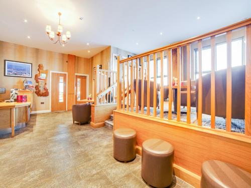 a large room with wooden walls and a staircase with stools at Standing Stones Lodge in Belfast