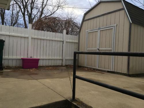 a white fence and a building with a garage at The Paradise @ Lyncott in Lansing