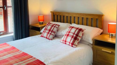 a bed with two red and white pillows on it at Rendezvous in Aviemore