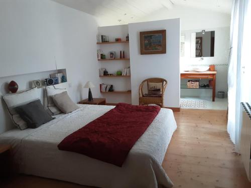 - une chambre avec un grand lit et un bureau dans l'établissement Les Jardins de Clerjotte, à Saint-Martin-de-Ré