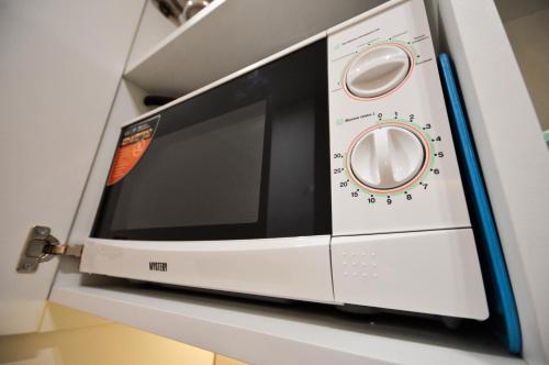 a white microwave oven sitting on a shelf at Kyiv Center Smart Apartments in Kyiv