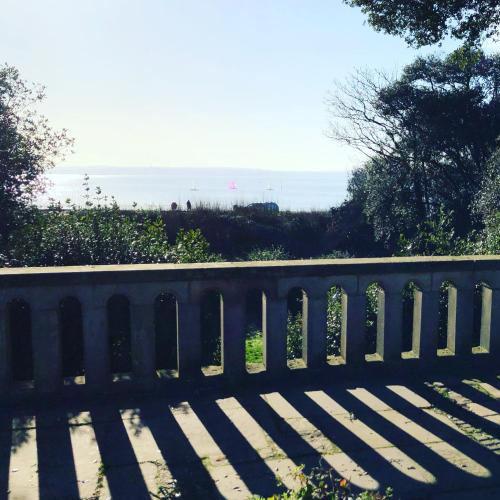 a bench with the ocean in the background at The Alverbank Hotel in Gosport