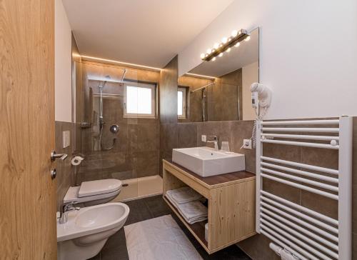 a bathroom with a sink and a toilet and a shower at Appartement Wiere in Molini di Tures