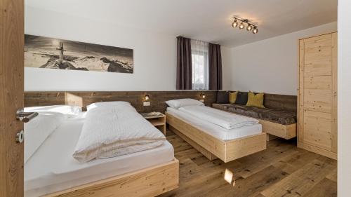 a bedroom with two beds and a couch at Appartement Wiere in Molini di Tures